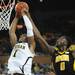 Michigan freshman Glenn Robinson III makes a dunk around Iowa sophomore Gabriel Olaseni in the second half at Crisler Center on Sunday, Jan. 6. Michigan beat Iowa 95-67 in the Big Ten home opener. Melanie Maxwell I AnnArbor.com